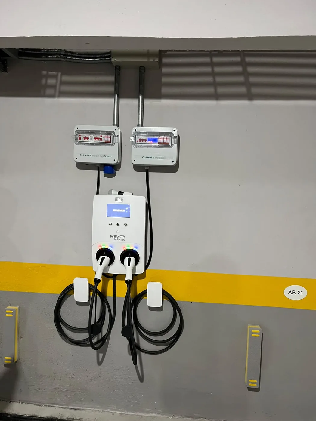 Estação de recarga dupla instalada em vaga de garagem de condomínio, com proteção individual por ponto