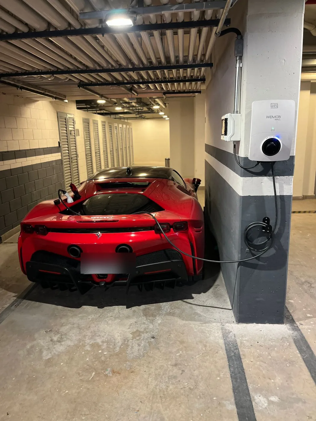 Carregador de parede instalado em pilar de garagem, com carro conectado carregando